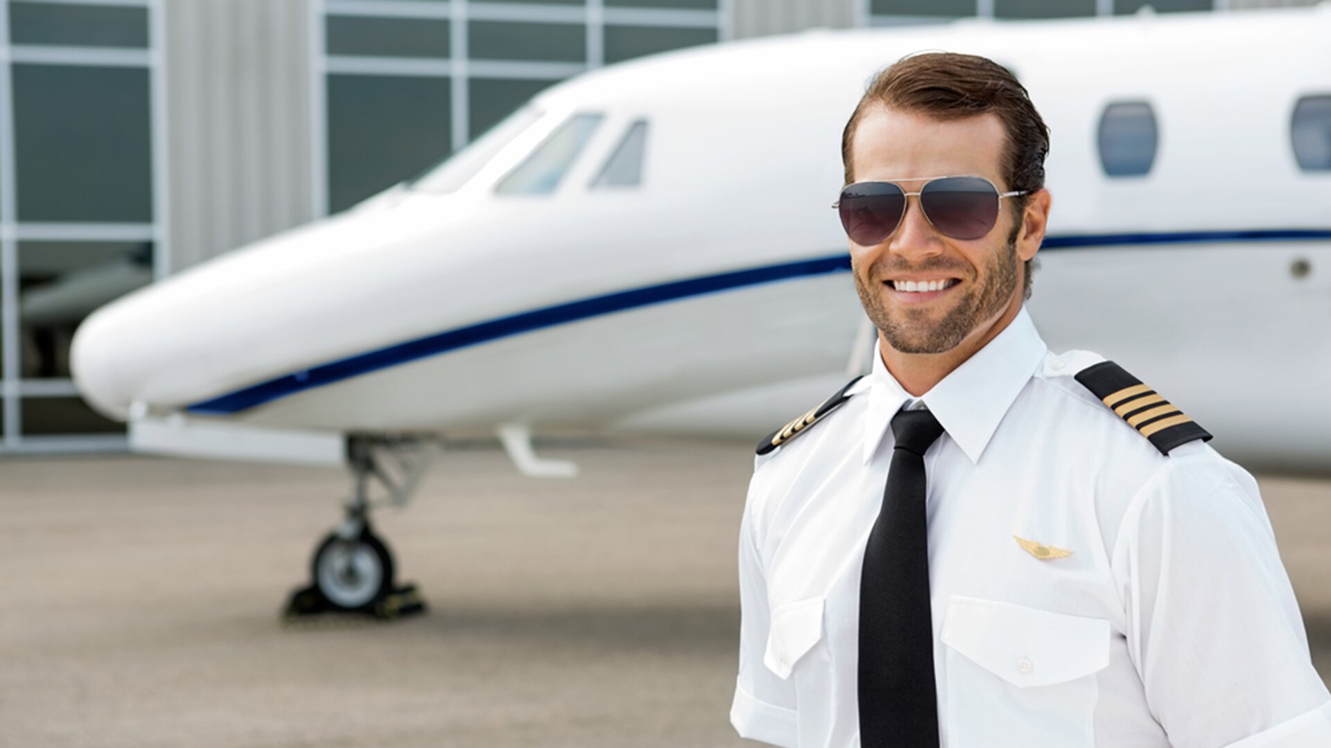 Confident pilot smiling in front of private jet; Shutterstock ID 171215267; PO: today.com